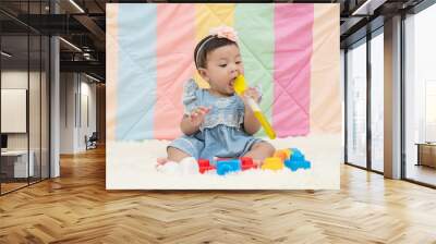 Asia baby girl  playing toys and put the toy in the mouth on white background. Wall mural