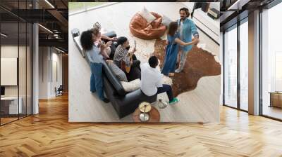 Multiethnic friends gathering in modern living space and celebrating party with music and dance. Couple dancing while others playing guitar and enjoy snacks and drinks at home in weekend
 Wall mural