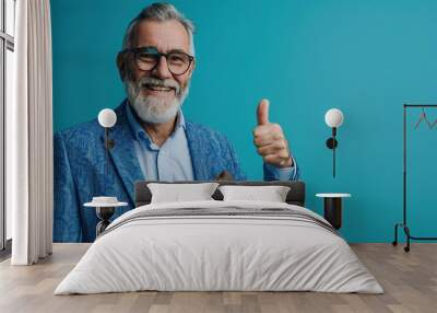 A successful senior hipster businessman wearing a casual and classy blue suit, relax and cool with a smile, positive and confident, thumb up an empty blue background with copy Wall mural