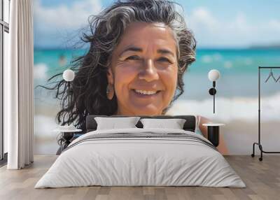 A woman with long hair is smiling at the camera on a beach Wall mural