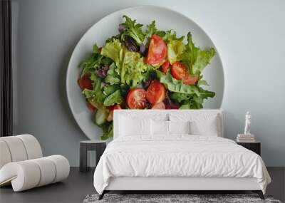 Fresh vegetable salad with mixed greens and cherry tomatoes on a white plate Wall mural