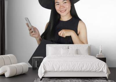 Smiling woman wearing witch costume using smartphone buy product online isolate on transparent background Wall mural