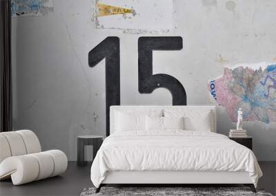 A house number plaque, showing the white coloured number fifteen (15) Wall mural