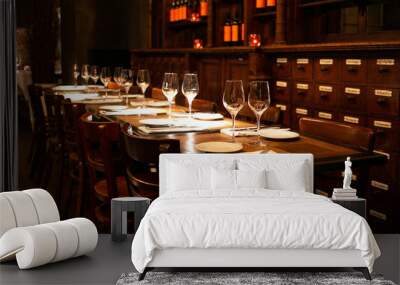 Glasses on the wooden table and chairs in a restaurant at night with interior lights in Antwerp, Belgium Wall mural