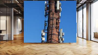 Modern antenna receivers are located on an old brick pipe. Wall mural