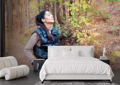 Relaxed woman breathing fresh air in a green forest Wall mural