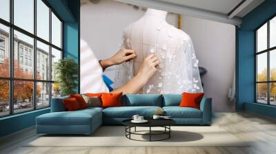 Work process of a tailor in her studio. Adjusting bridal dress process, lace gown on mannequin.
 Wall mural