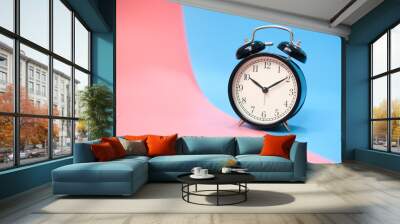 Black vinatge alarm clock with pink and blue background. Wall mural