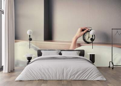 Woman sleep on the bed turns off the alarm clock wake up at the morning, Selective focus. Wall mural