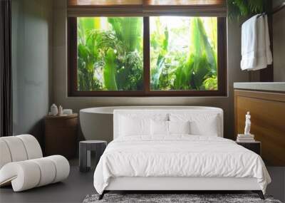 A white bathtub with a view of a lush green forest. A basket is placed next to the tub Wall mural