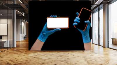 Doctor's hand in medical gloves holding phone isolated on black Wall mural