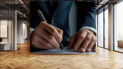 A man in a suit is signing a document with a pen. Concept of formality and professionalism, as the man is dressed in a suit and tie while signing the document Wall mural