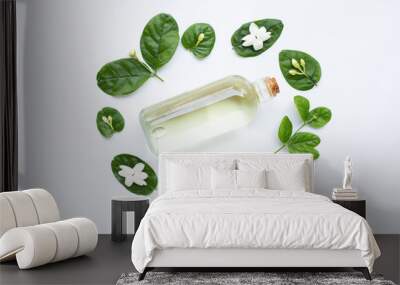 Bottle of essential oil with jasmine flower and leaves on white. Wall mural