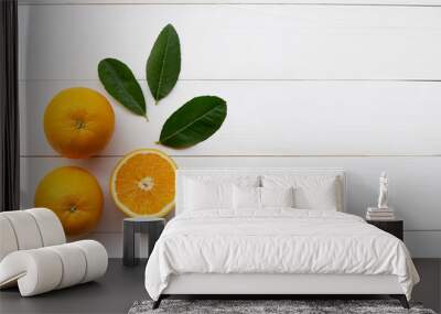 Orange citrus fruit and green leaves on white wooden Wall mural