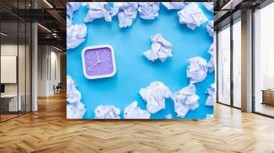 Square clock with white crumpled paper balls on a blue background. Wall mural