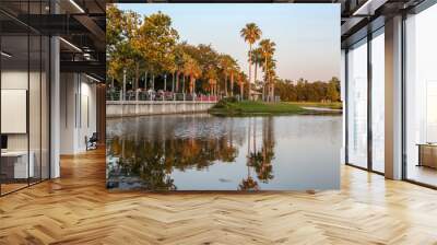 The magnificent sunset landscape at Celebration, Orlando, Florida, USA. A modern design leisure area in a wooded area, the water mirror on the lake reminiscent of nature. Wall mural