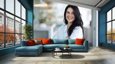 Beautiful and confident Caucasian female dentist with a friendly smile standing inside a blurry modern clinic Wall mural