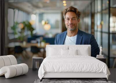 Handsome businessman in formal blue suit combined with white t-shirt smiling in modern office with conference room background, posing with hands in trouser pockets Wall mural