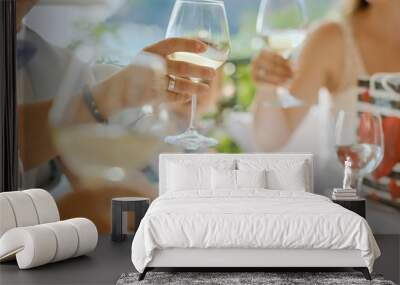 People hands with glasses of wine or champagne at a table on the terrace. Friends meeting Wall mural