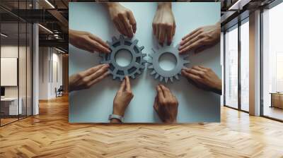 Group of business hands carefully placing interlocking gears on table, symbolizing teamwork and cooperation in business circles Wall mural