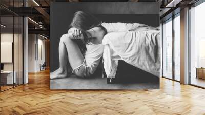 Depressed woman sitting alone in bedroom. Wall mural