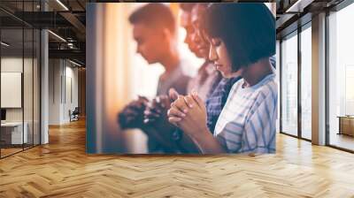 Asian Christian groups sitting within the Church Catholic. They clasped hands and closed his eyes and prayed for blessings from God. A pale sun shone in a place of worship with copy space. Wall mural