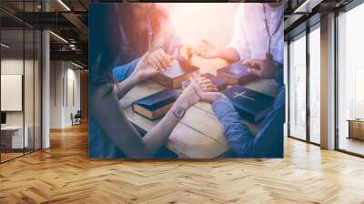 Group of Christians are congregants join hands to pray and seek the blessings of God, the Holy Bible. The cross symbol. They were reading the Bible and sharing the gospel with copy space. Wall mural