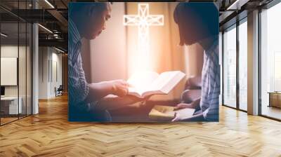 Male adults are reading the Bible holy bible by pointing to the character and to share the gospel to youth. The cross symbol, glow over the books of the Bible, Concepts of Christianity. Wall mural