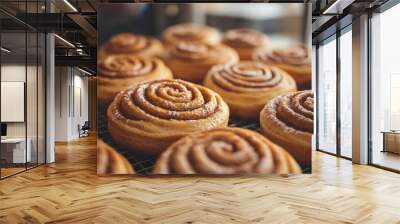 Freshly baked cinnamon rolls cooling on a wire rack in a bakery Wall mural