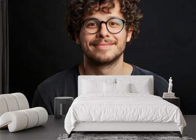 smiling man with curly hair and glasses Wall mural