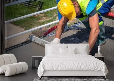 Worker with yellow helmet straighten and smoothing fresh concrete on a construction site Wall mural