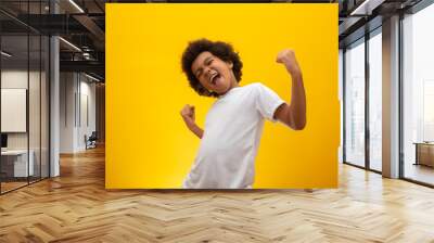 African American boy with black power hair on yellow background. Smiling black kid with a black power hair. Black boy with a black power hair. African descent. Wall mural