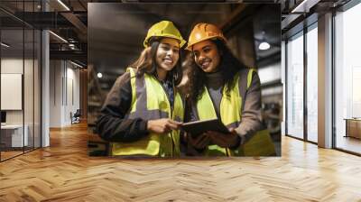 Teamwork of factory female workers in safety uniform holding a tablet in a factory. Generative AI. Wall mural