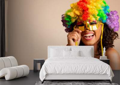 Beautiful woman dressed for carnival night. Smiling woman ready to enjoy the carnival with a colorful wig and mask Wall mural