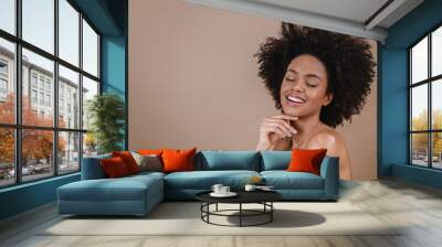 Closeup of a smiling young Latin afro woman. Joy, positive and love. Beautiful african-style hair. Pastel studio background. Wall mural