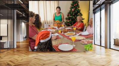 Summer Christmas dinner in Brazil. Real Brazilian family having fun at the Latin American Christmas party. latin woman holding a delicious christmas turkey Wall mural