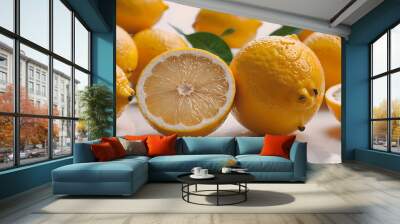 A lemon is cut in half and has a green leaf on top Wall mural