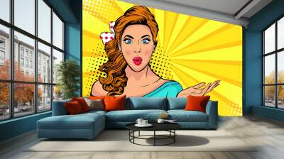 Wow pop art face of surprised fashion girl open mouth. Beautiful young woman model pointing hand, advertising gesture.  Vector bright background in pop art retro comic style. Wall mural