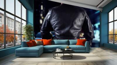 Biker man in leather jacket standing on night city street back view. Wall mural