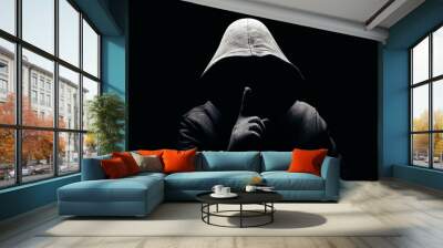 Photo of a scary horror man in hoodie showing silence hand sign in dark. Wall mural