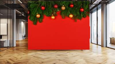 Decorated fresh Christmas tree branches over red Wall mural