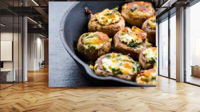 Baked champignons mushrooms, filled with cheese, parsley and roasted garlic in black bowl. Wall mural