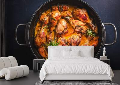 Baked chicken drumsticks with vegetables, casserole dish on black background Wall mural