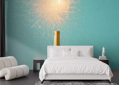 A bottle of wine adorned with a mini firework sparkler stands on a pink table against a blue backdrop. The lighting creates dynamic shadows. The scene captures the festive spirit of Christmas Wall mural