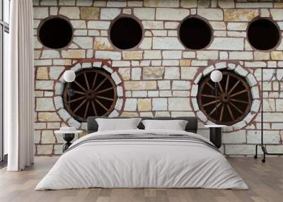 Rustic stone wall wagon wheels embedded decoration western feature design. Wall mural