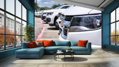 White generic vehicle fleet SUVs transportation parked row closeup front vehicle focus on foreground logistics industry. Wall mural