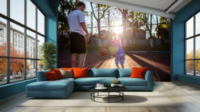 Young millennial father playing basketball with his little daughter Wall mural