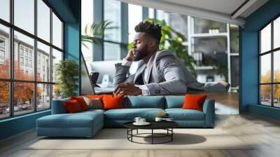 Black man stretching in office wearing professional business suit Wall mural