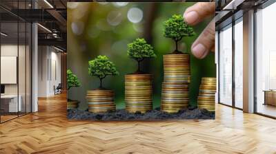 growing wealth concept with hand placing miniature trees on coin stacks Wall mural