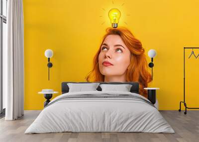 Idea - woman with a lightbulb over her head isolated with copy space on yellow background Wall mural